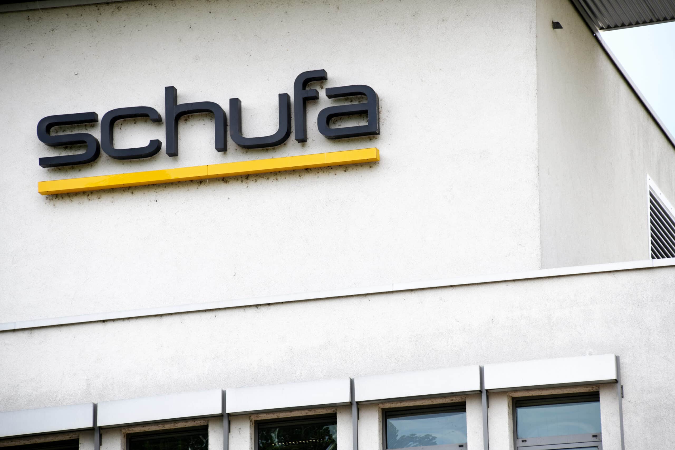 SCHUFA: Firmenschriftzug an der Gebäudefassade SCHUFA-Schriftzug mit gelbem Balken an der Fassade eines Bürogebäudes