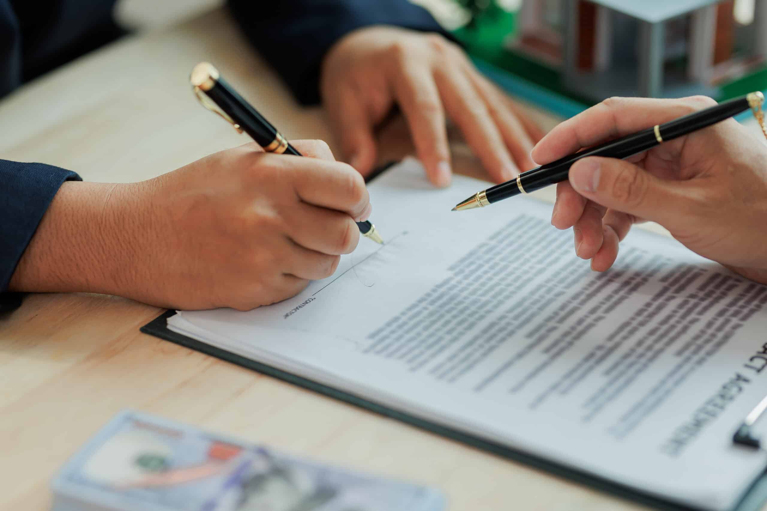 Kreditvertrag Bürgschaft Unterschrift Zwei Personen unterschreiben einen Vertrag am Tisch
