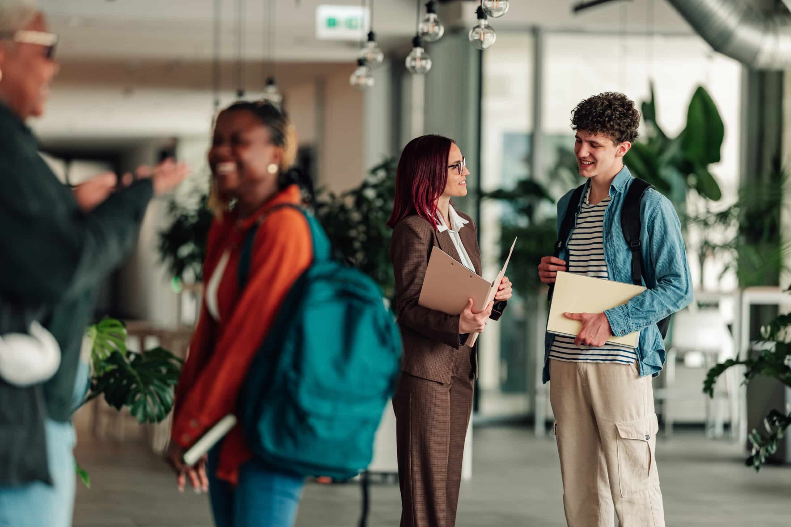 Studienfinanzierung Beratung Studierende Hochschule Studierende im Gespräch mit einer Beraterin in einer Hochschulhalle