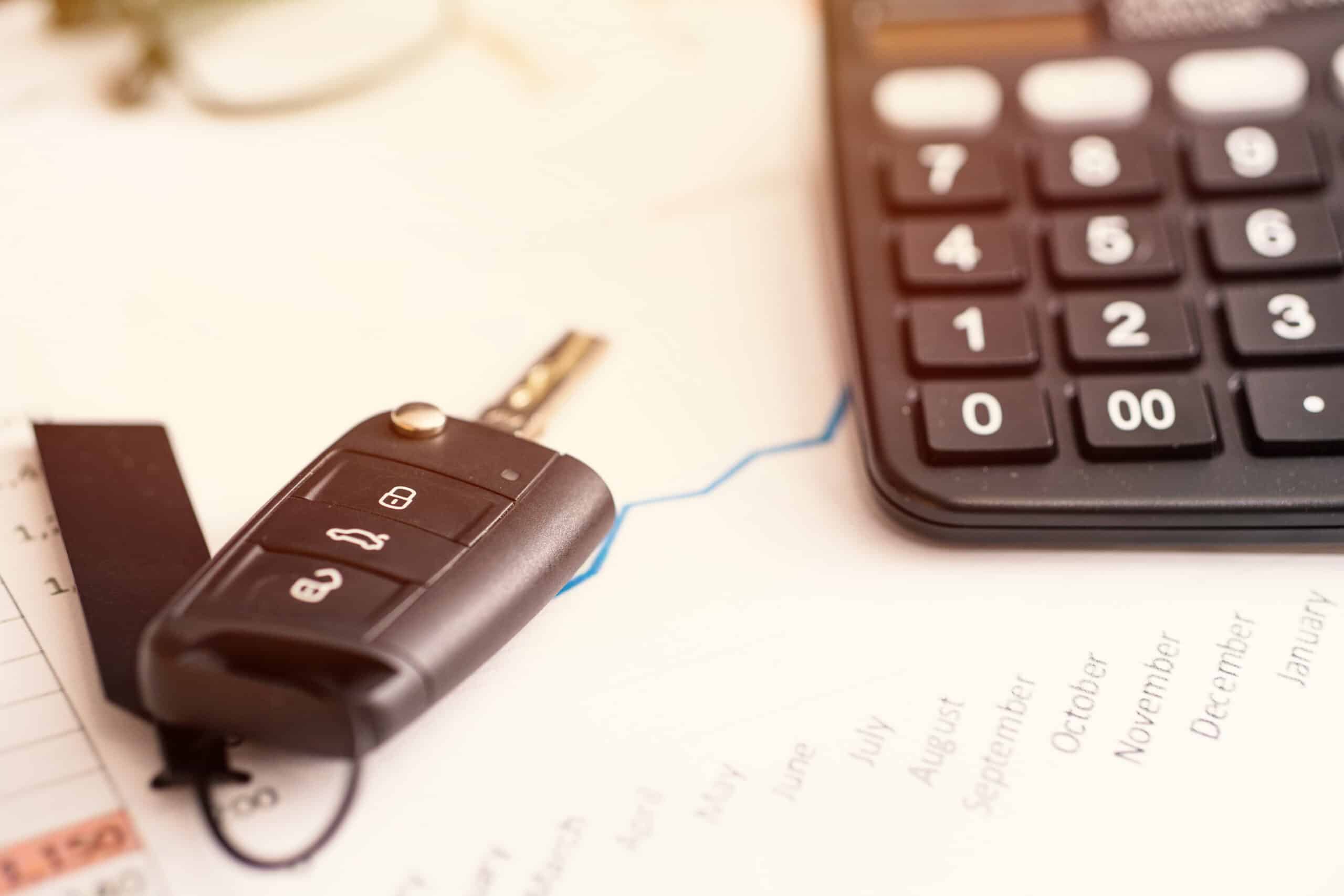 Autofinanzierung Kosten Taschenrechner Monatsrate vergleichen Autoschlüssel neben Taschenrechner und Kostenkurve zur Autofinanzierung